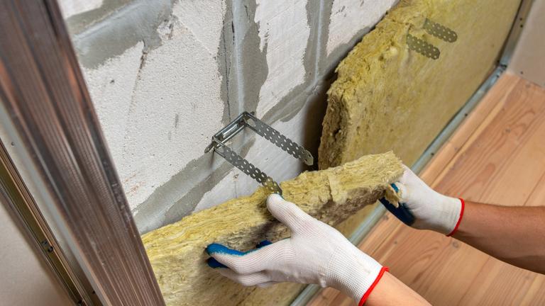 worker-insulating-room-wall-with-mineral-rock-wool-thermal-insulation